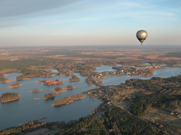 a hot air balloon flying over a large body of water