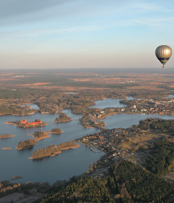 a hot air balloon flying over a large body of water